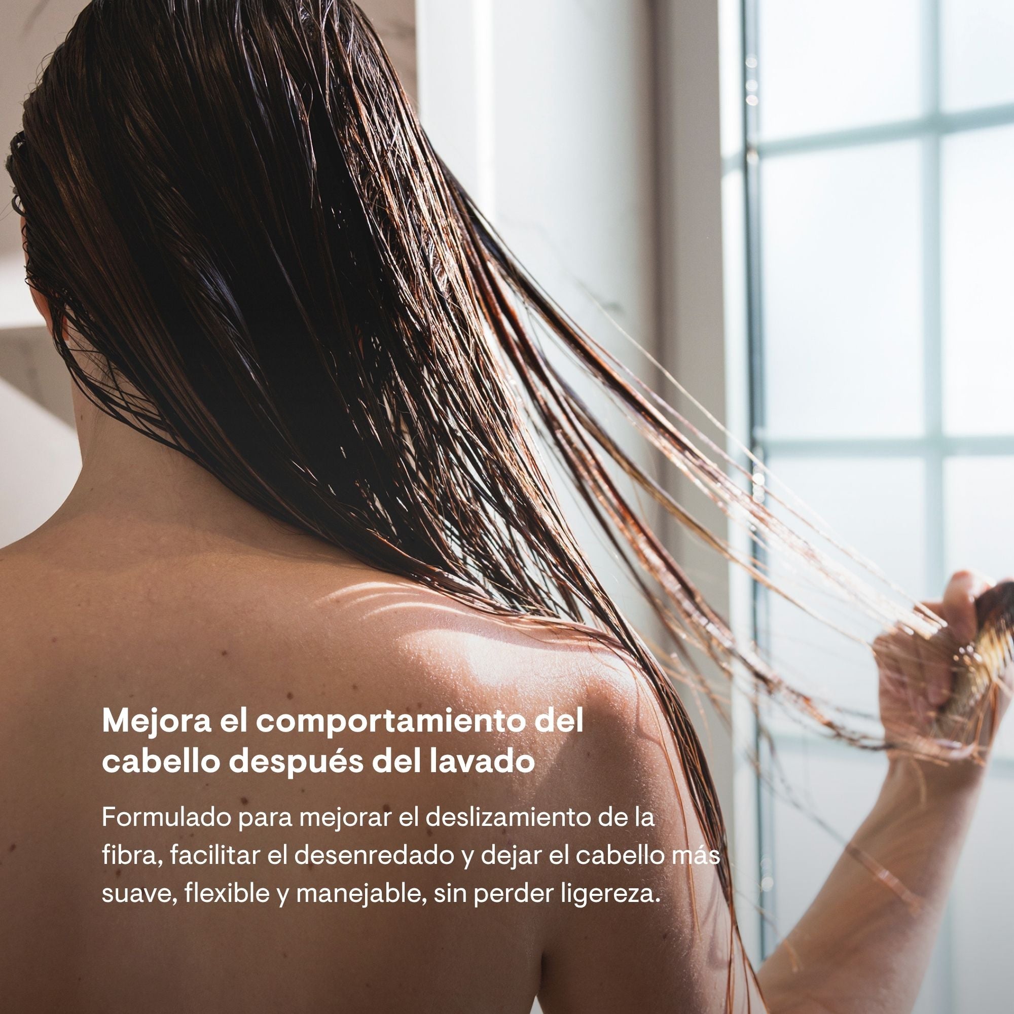 Mujer aplicando el acondicionador H04 de Modesta Cassinello en la ducha, mejora el deslizamiento de la fibra y facilita el desenredado dejando el cabello suave y manejable